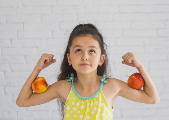 Kind met appels tussen gespannen armen